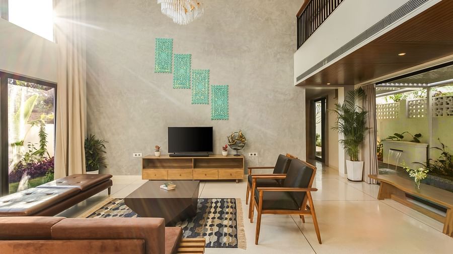 A spacious living room with a double-height ceiling, contemporary furniture, and a large window offering natural light - BluSalzz Villas - Alocassia, Anjuna