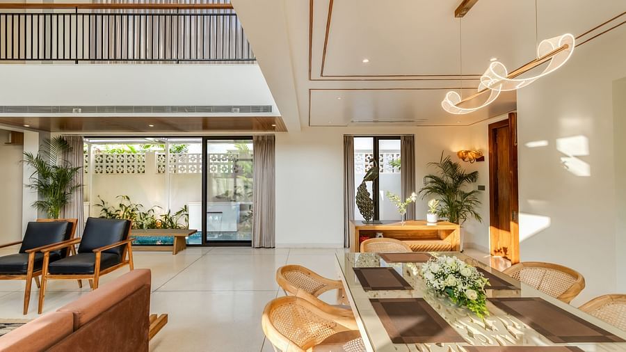 A spacious living room with a double-height ceiling, modern decor, and comfortable seating arranged around a coffee table.