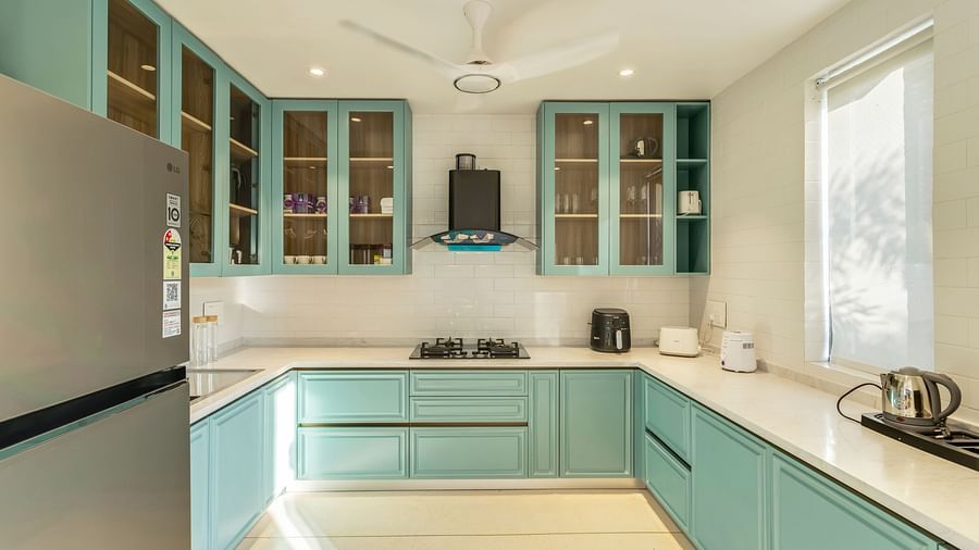 A contemporary kitchen with pastel blue cabinets, integrated appliances, and ample natural light creating an airy and functional space - BluSalzz Villas - Alocassia, Anjuna