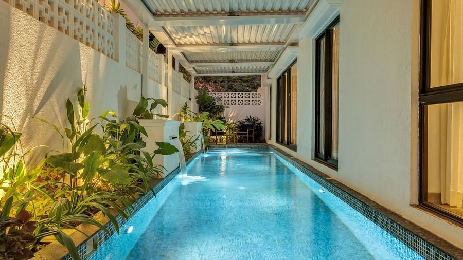 A serene swimming pool running alongside the villa, surrounded by lush greenery and modern architectural elements - BluSalzz Villas - Alocassia, Anjuna