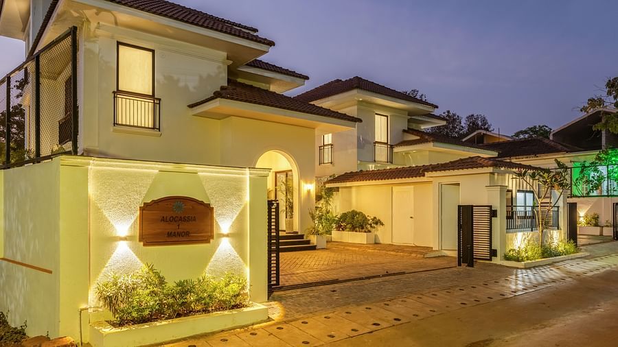 A well-lit villa exterior at dusk, showcasing elegant architectural details and landscaped gardens - BluSalzz Villas - Alocassia, Anjuna