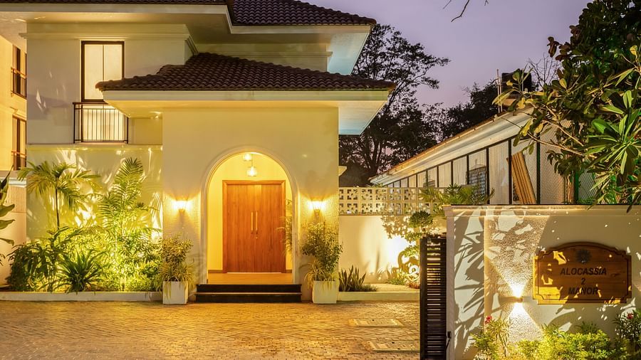 A luxurious villa exterior at night, showcasing elegant design, warm lighting, and a landscaped driveway - BluSalzz Villas - Alocassia, Anjuna