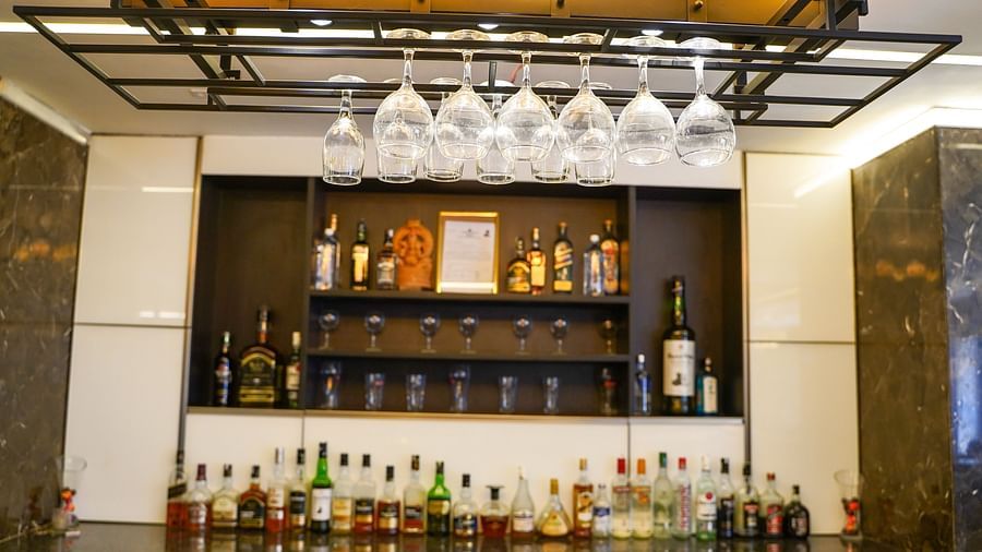 A close-up view of the modern light fixtures and hanging wine glasses above a bar or dining area at BNGV Grandeur Hotel and Banquets.