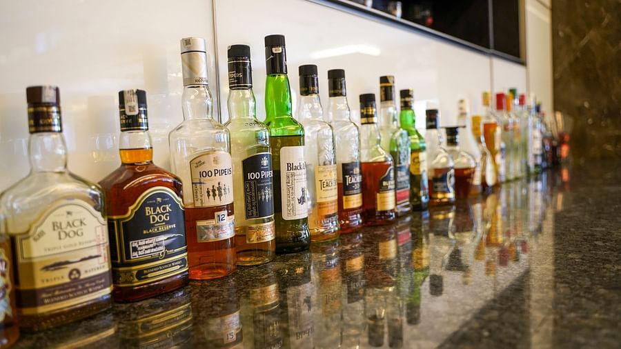 A close-up of a well-stocked bar counter at BNGV Grandeur Hotel and Banquets, displaying various bottles of liquor and spirits.