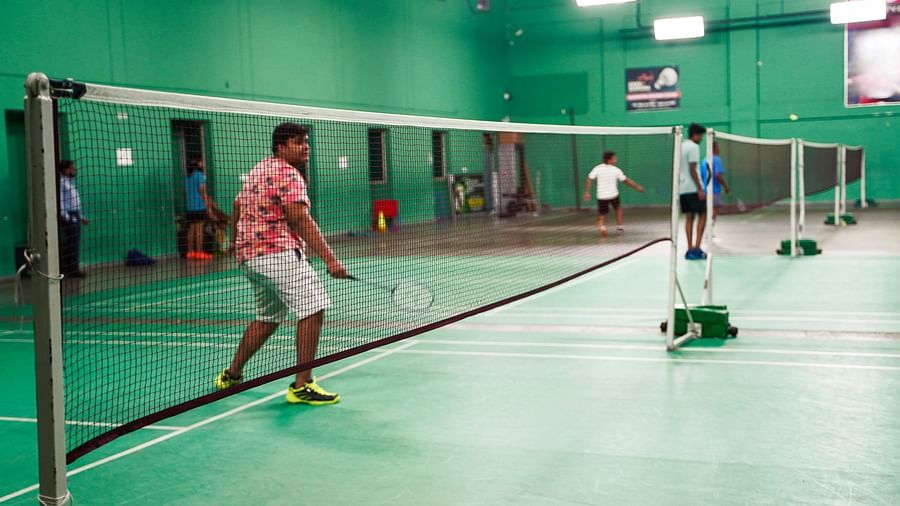  An indoor badminton court with a player near the net, seen at BNGV Grandeur Hotel and Banquets.