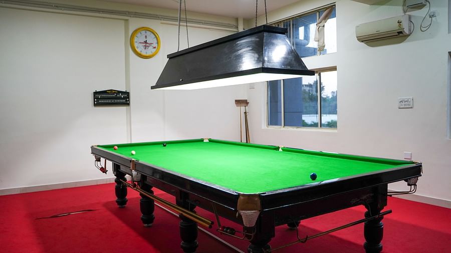 A snooker table with a green felt surface under professional lighting at BNGV Grandeur Hotel and Banquets.