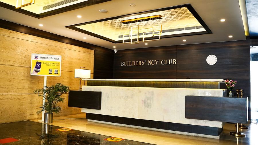 The modern reception counter of the hotel lobby at BNGV Grandeur Hotel and Banquets, with elegant lighting and dark accents.