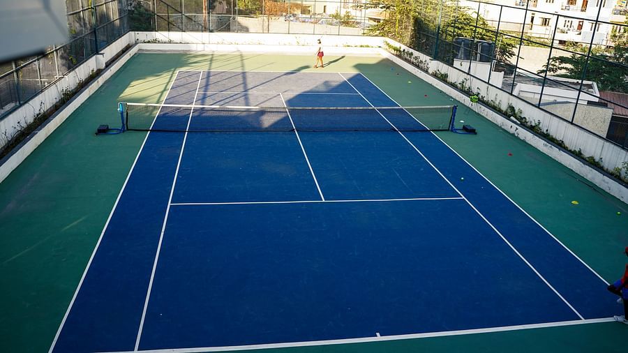  A vibrant outdoor tennis court with blue and green playing surfaces, ready for a match at BNGV Grandeur Hotel and Banquets.