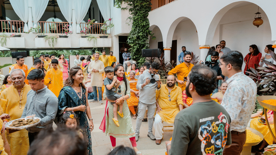A group of guests socializing, smiling, enjoying a celebratory event in an outdoor courtyard at Bougainvillea, Alibaug.