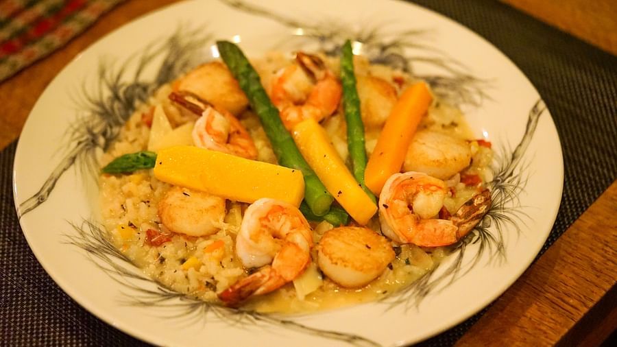 A beautifully arranged plate of shrimp, sautéed vegetables, and colorful garnishes for a light, yet flavorful meal - Brewery Gulch Inn & Spa