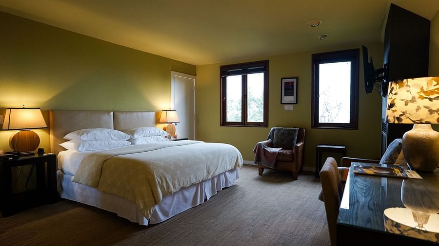 Warm and inviting hotel room with soft lighting, a plush bed, and a scenic view from the window - Brewery Gulch Inn & Spa