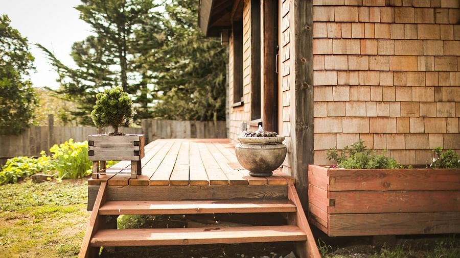 Wooden deck with steps leading to the massage room, surrounded by lush greenery - Brewery Gulch Inn & Spa