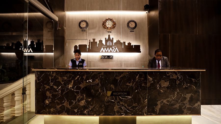 Image of a reception area with a man and a woman standing behind the table at Calux Grand Baga.