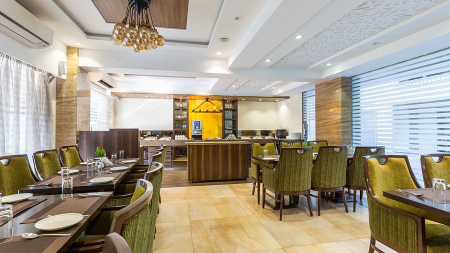 Image of a dining area with tables and chairs at Calux Grand Inn, Calangute.