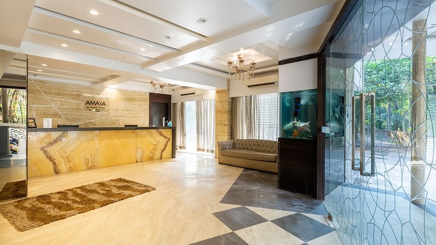 Image of a lobby area with a reception table and large glass doors at Calux Grand Inn, Calangute.