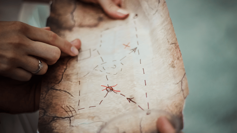 a zoomed image of a Person reading an old map 