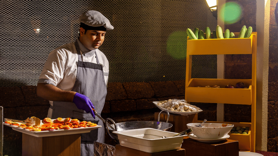 a chef preparing food inside the kitchen at caravela beach reasort goa 