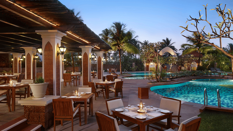 An overview of the al fresco dining at Castaways restaurant at Caravela Beach Resort next to the pool as seen during twilight hour.
