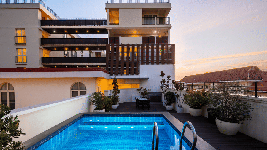 Rooftop swimming pool with lounge seating and views of the surrounding city at Central Mansions, Phnom Penh.