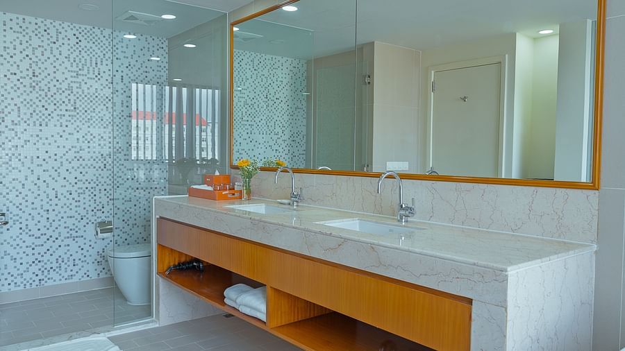 A bathroom with a large mirror, sink, and countertop | Penthouse | Central Mansions, Phnom Penh