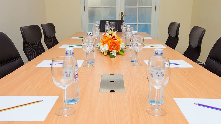A meeting room with a long table, chairs, and glasses | Conference Hall | Central Mansions, Phnom Penh