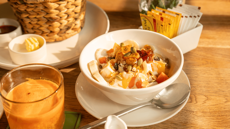 Bowl of breakfast food served with fresh juice, coffee, and accompaniments at Central Mansions, Phnom Penh.
