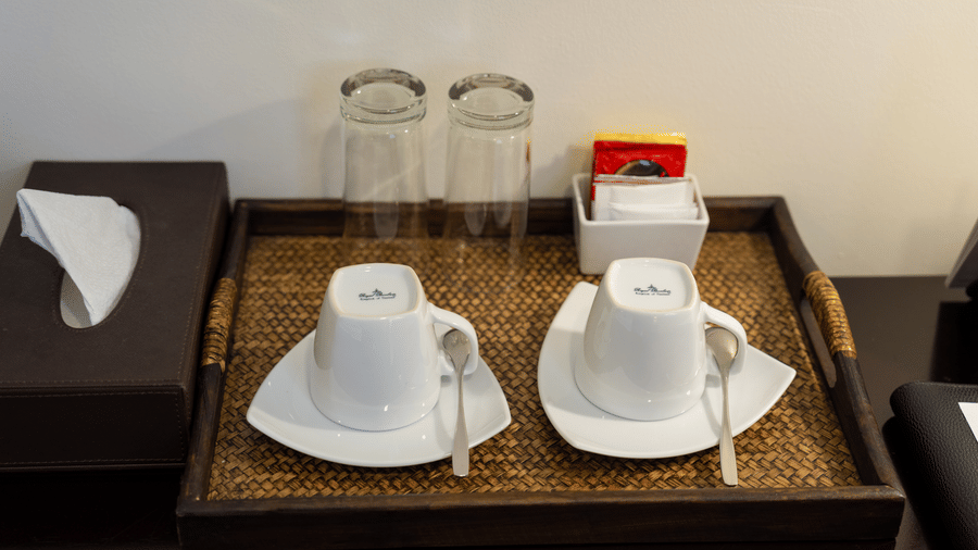 Coffee and tea service with cups, saucers, and drinking glasses at Central Mansions, Phnom Penh.