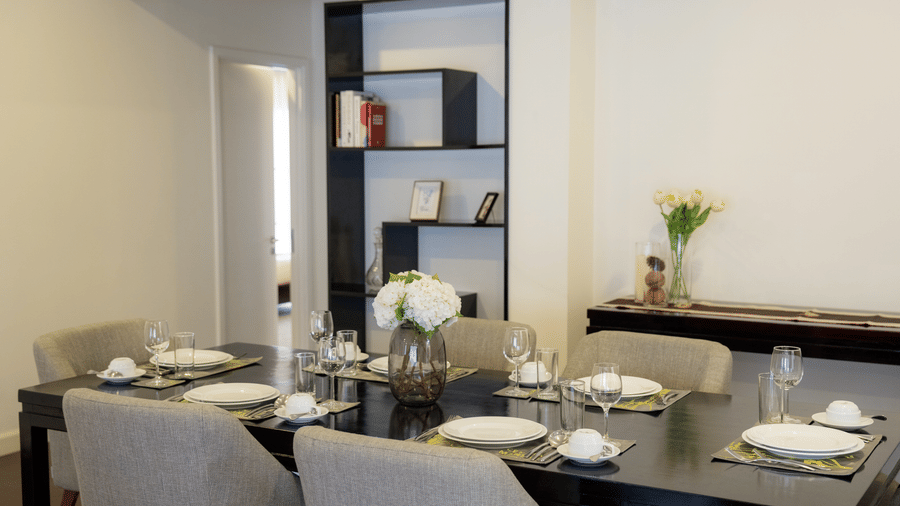 Dining area with a table set with crockery and chairs at Central Mansions, Phnom Penh.