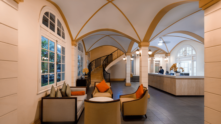 Elegant lounge with arched ceilings, comfortable seating, and large windows at Central Mansions, Phnom Penh.
