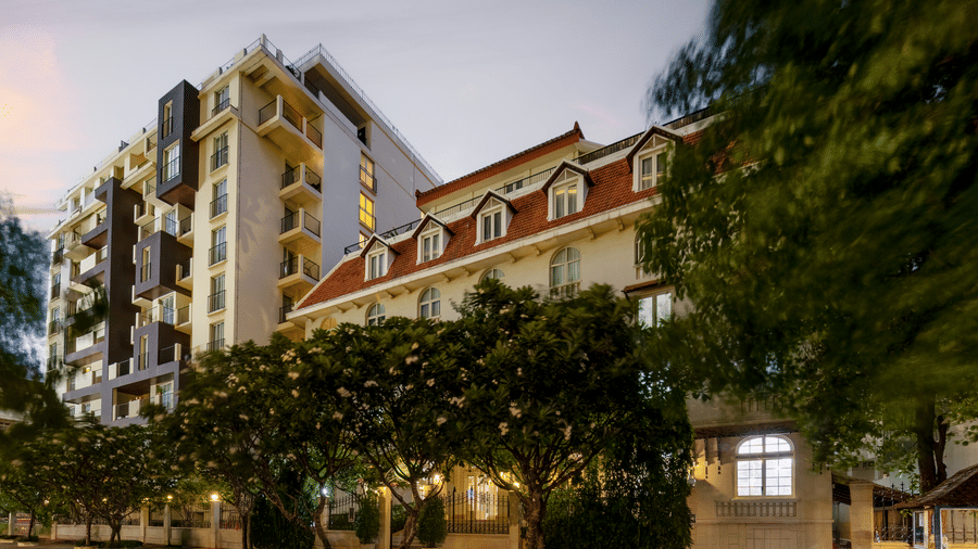 Exterior view of Central Mansions, Phnom Penh, surrounded by trees and landscaped grounds.