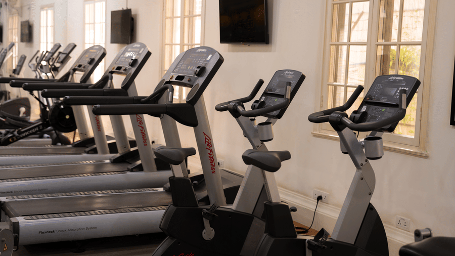 Fitness centre equipped with treadmills, exercise bikes, and a wall mounted television at Central Mansions, Phnom Penh.