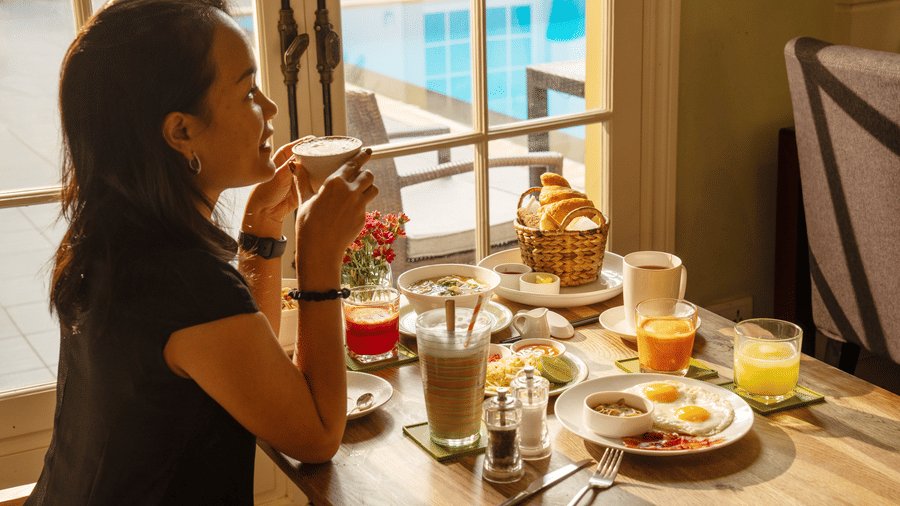 Guest enjoying breakfast with a selection of dishes and beverages at Central Mansions, Phnom Penh.
