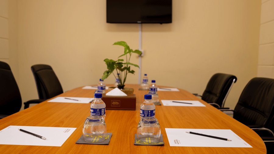 Meeting room with a conference table, chairs, notepads, and bottled water at Central Mansions, Phnom Penh.