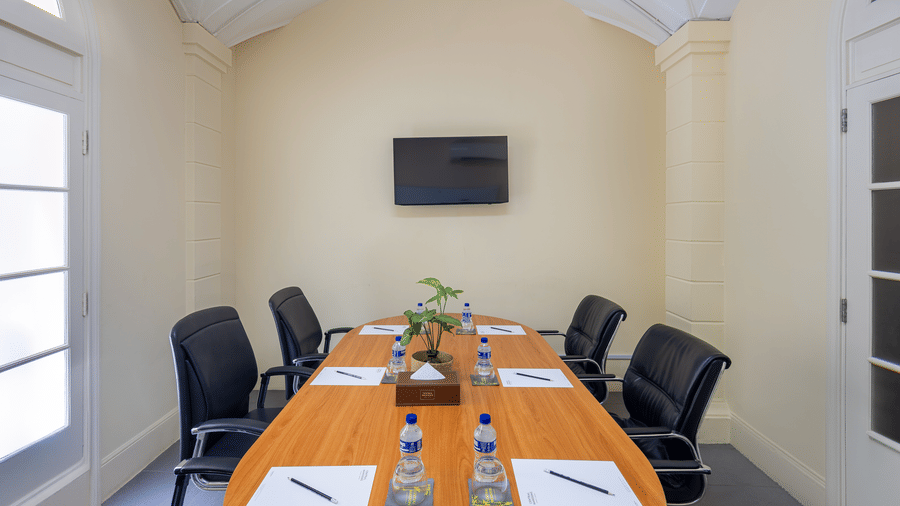 Meeting room with a conference table, chairs, and presentation screen at Central Mansions, Phnom Penh.