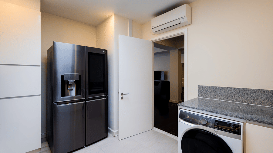 Laundry area in the Penthouse at Central Mansions, Phnom Penh with a washing machine, refrigerator, and storage space.