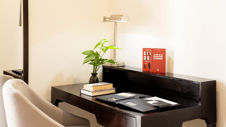 Work desk with a chair, lamp, and decorative plant at Central Mansions, Phnom Penh.