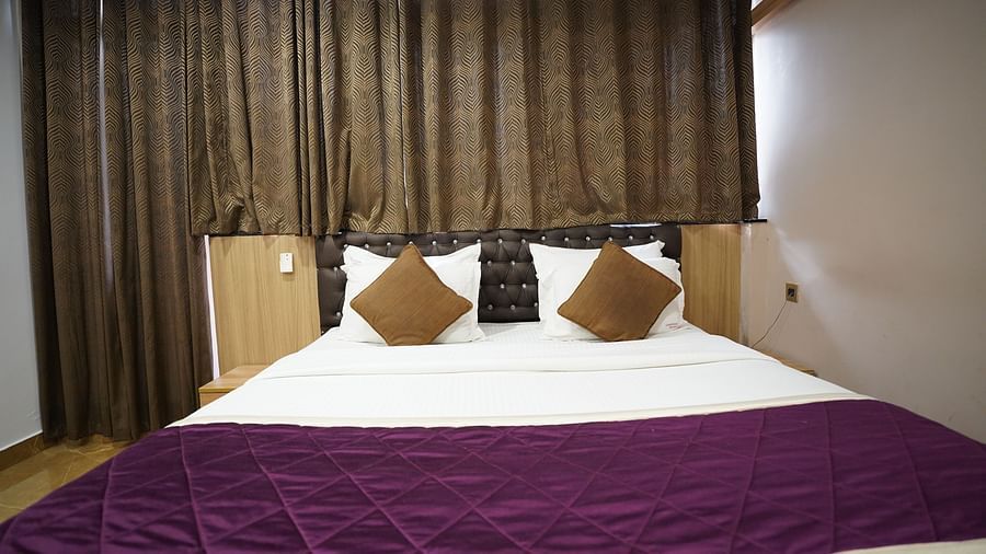 an image of close up shot of deluxe room with curtains behind the headboard