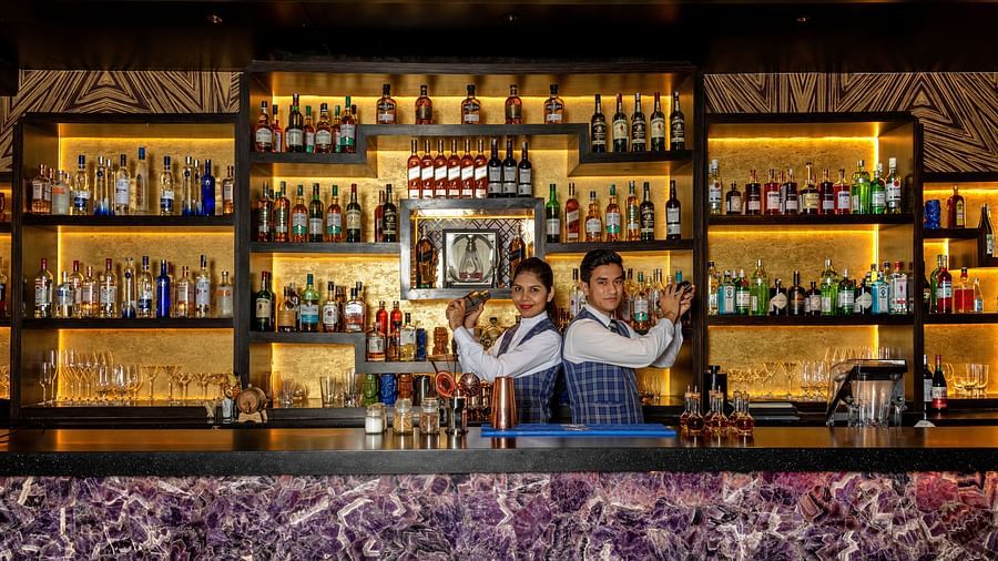 Two bartenders shaking drinks while standing back to each other - Claridges Collection