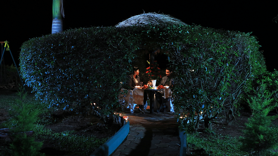 Image of two people dining at an outdoor setting at Coorg Jungle Camp Backwater Resort, Kushalnagar.