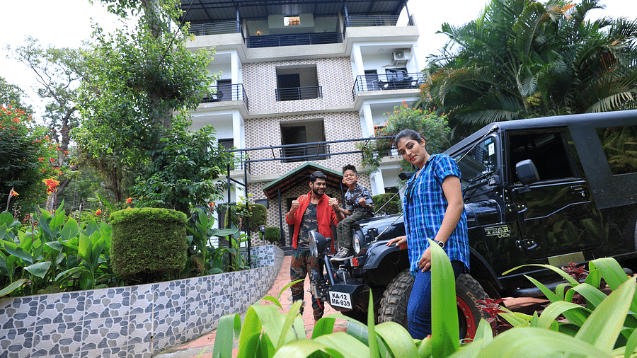 Image of three people standing in front of a car posing for a photo at Coorg Jungle Camp Backwater Resort, Kushalnagar.
