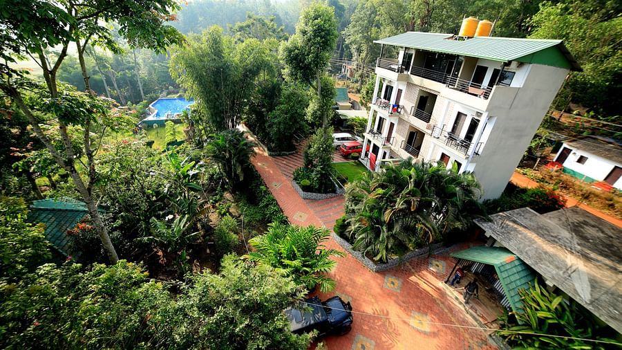 Facade of a building surrounded with plants at Coorg Jungle Camp Backwater Resort, Kushalnagar.
