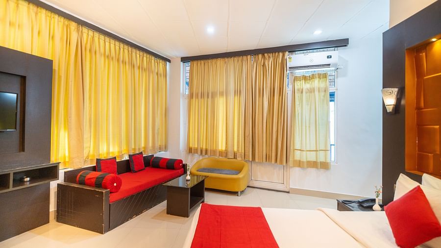 Side view of a room with a bed and a seating area at Coorg Jungle Camp Backwater Resort, Kushalnagar.