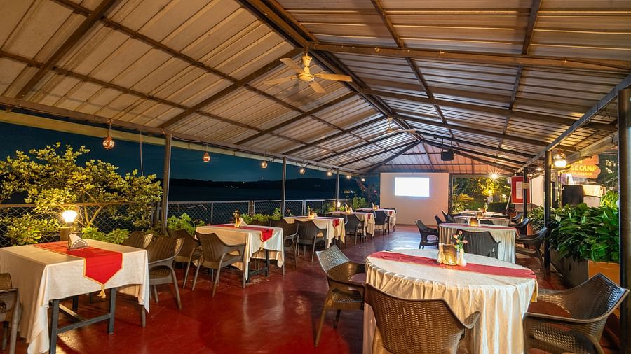 Image a dining area with a slanted roof and tables and chairs at Coorg Jungle Camp Backwater Resort, Kushalnagar.