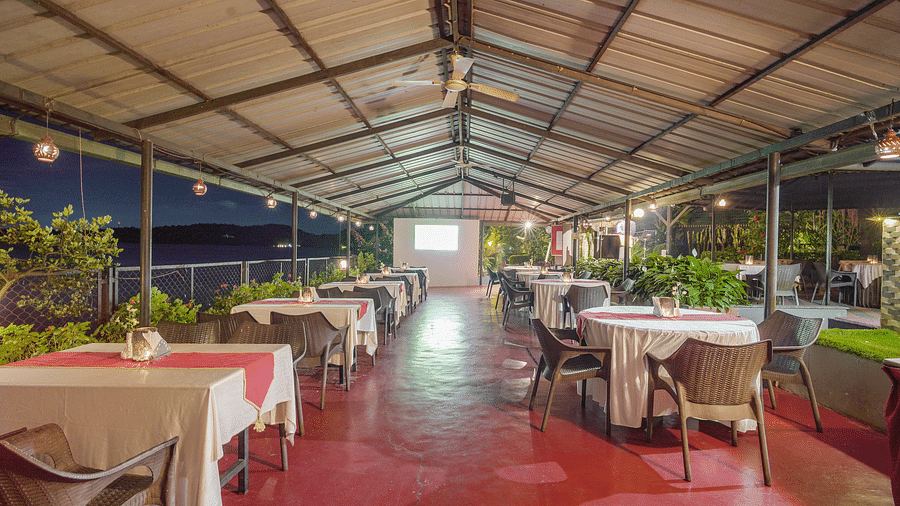Image of a dining space with tables and chairs around it at Coorg Jungle Camp Backwater Resort, Kushalnagar.