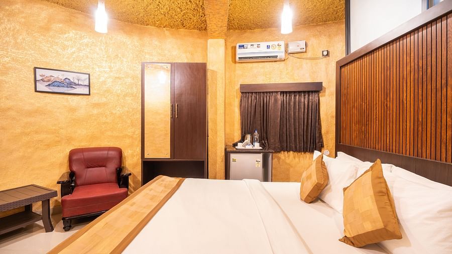 Image of a room with a bed and a chair on the side at Coorg Jungle Camp Backwater Resort, Kushalnagar.