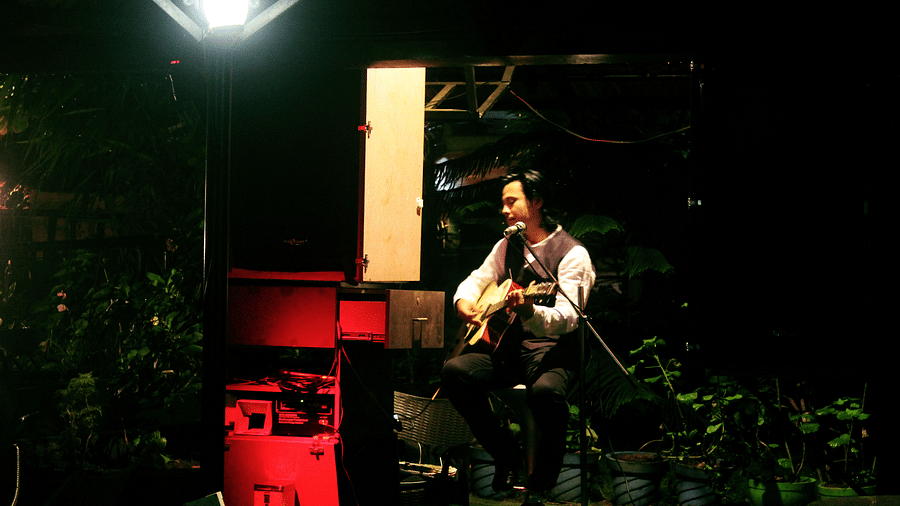 Image of a man playing a guitar at Coorg Jungle Camp Backwater Resort, Kushalnagar.