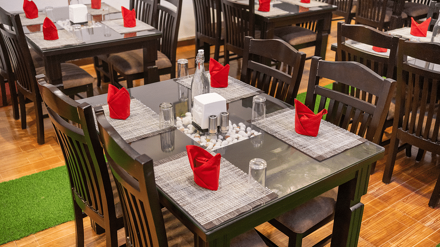 Image of a dining space with towels arranged on it at Coorg Jungle Camp.