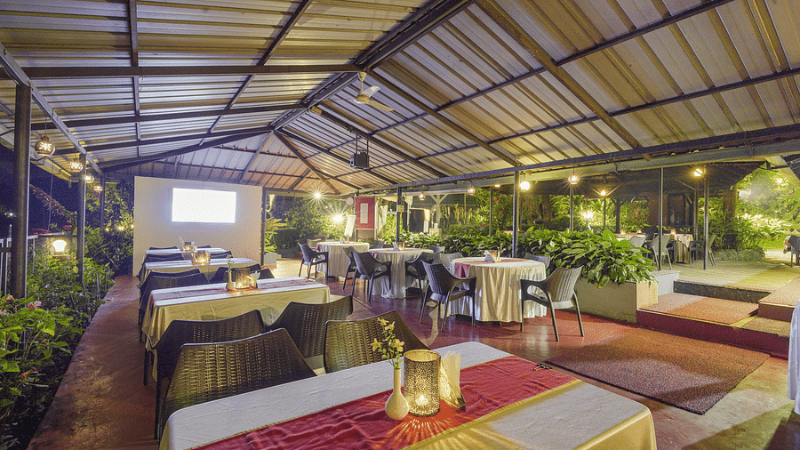 Image of a dining space with rectangular tables and chairs around it at Coorg Jungle Camp.