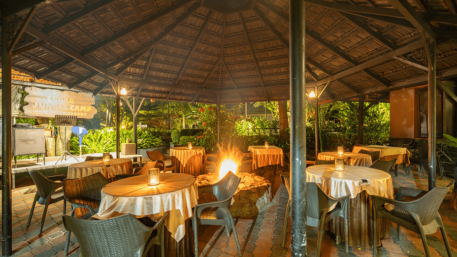 Image of a dining space with circular tables and chairs around it at Coorg Jungle Camp.