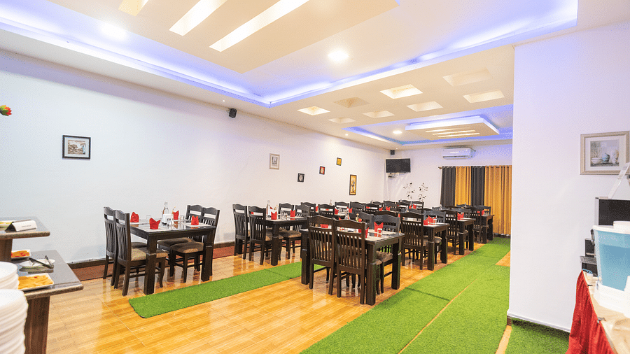 Side view of a dining space with tables and chairs at Coorg Jungle Camp.